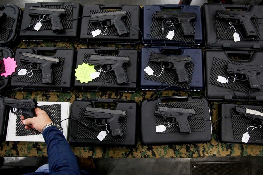 A visitor to the High Caliber Gun and Knife Show at the George R. Brown Convention Center holds a handgun at the Starnes Company Guns booth Saturday Jan. 2 2016 in Houston