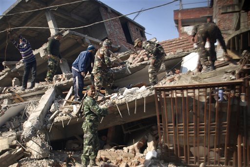 Indian soldiers and locals remove debris from a damaged building after an earthquake in Imphal capital of the northeastern Indian state of Manipur Monday Jan. 4 2016. A 6.7 magnitude earthquake hit India's remote northeast region before dawn on M