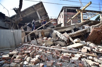 Indian men search through the debris of a collapsed building following a 6.7 magnitude earthquake in Imphal India