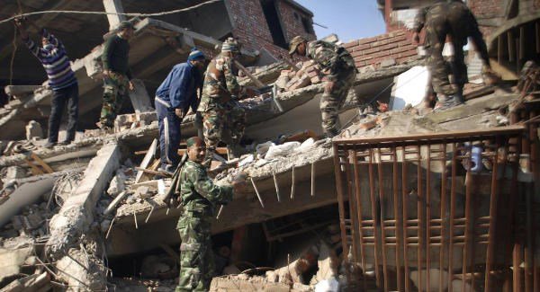 Indian soldiers and locals remove debris from a damaged building after the earthquake in Imphal