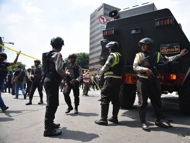 Indonesian armed police clear the area near a Starbucks after a series of blasts hit Jakarta