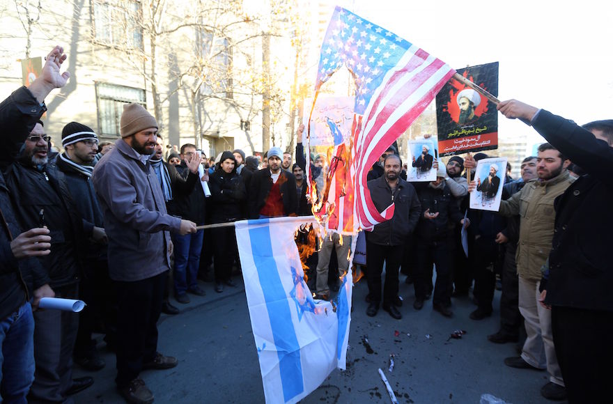 Iranian men burning Israeli and American flags during a demonstration against the execution of prominent Shiite cleric Nimr al Nimr by Saudi authorities Jan. 3 2016