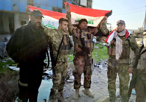 Iraqi soldiers hold national flags in the government complex in Ramadi 70 miles west of Baghdad. The complex´s capture is an important symbolic victory. Militants have occupied the city since May