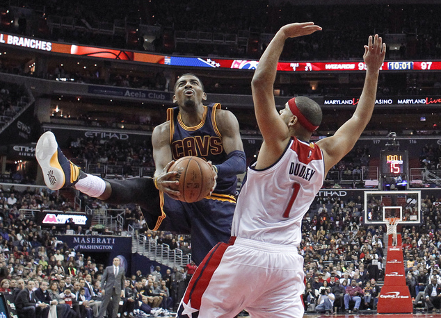 Cleveland Cavaliers guard Kyrie Irving shoots as Washington Wizards forward Jared Dudley defends during the second half of an NBA basketball game Wednesd