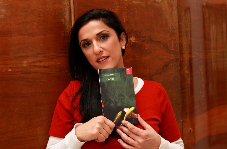 Israeli author Dorit Rabinyan with her Hebrew-language novel titled'Gader Haya  at her house in the coastal city of Tel Aviv. Rabinyan's book has been left off courses in a bid to avoid encouraging relationships between Jews and Arabs