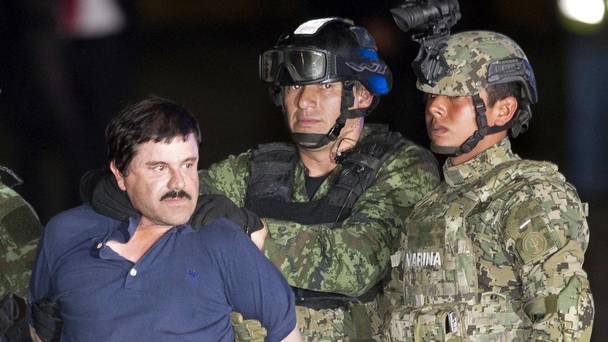 Joaquin'El Chapo Guzman is escorted to a helicopter in handcuffs by soldiers and marines