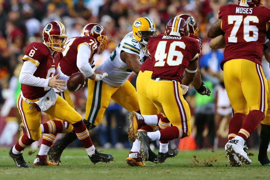 Quarterback Kirk Cousins #8 of the Washington Redskins drops back to hand off to running back Alfred Morris #46 of the Washington Redskins against the Green Bay Packers in the first quarter during the NFC Wild Card Playoff game at FedExField on January 10