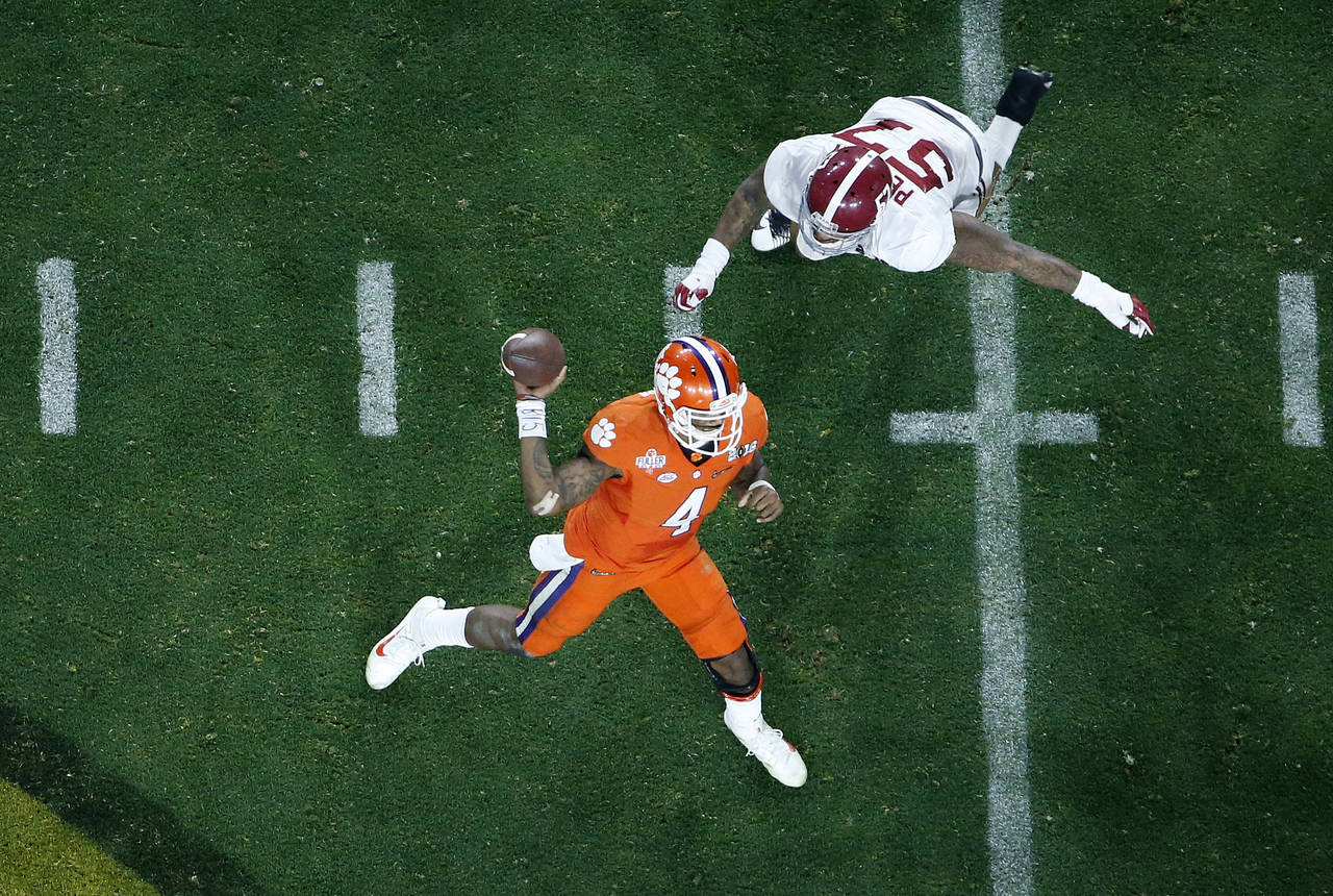 Clemson's Deshaun Watson throws while being rushed by Alabama's D.J. Pettway during the second half of the NCAA college football playoff championship game Monday Jan. 11 2016 in Glendale Ariz