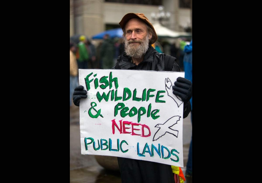 John Perry holds a poster during a rally against the occupation of the Malheur National Wildlife Refuge by Ammon Bundy and his armed followers while joining the rally at the Federal Building in Eugene Ore. Tuesday Jan. 19 2016