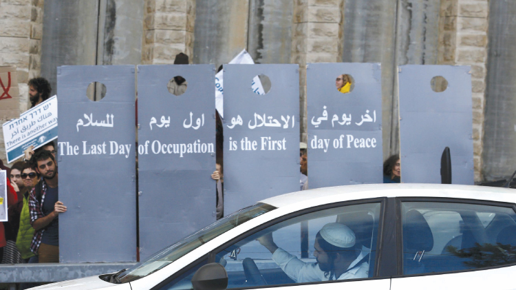 Left-wing Israelis hold placards during a demonstration at the West Bank calling for a better future for Palestinians. — Reuters