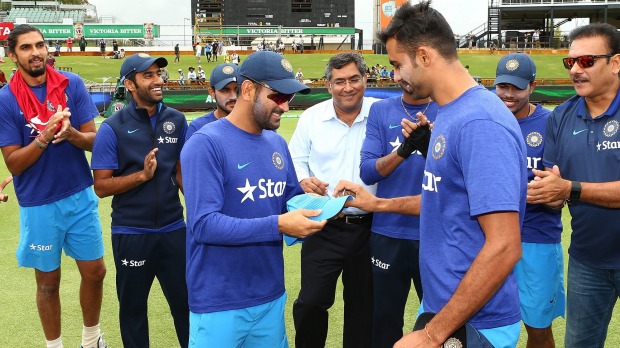 M.S. Dhoni presents Barinder Sran with his cap before the first one-day tie in Perth