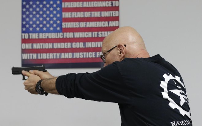 A trainer demonstrates how to safely fire a Glock 9mm hand gun during a Concealed Weapons Permit class in Pompano Beach Fla. last week