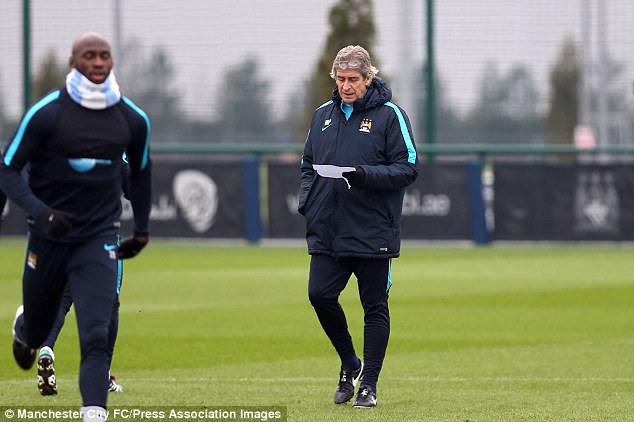 Manuel Pellegrini consults his notes during Manchester City's training session on Tuesday