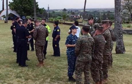 Military officials and Honolulu Police Department officers talked at a beach park where search and rescue officials are meeting in Haleiwa Hawaii on Friday