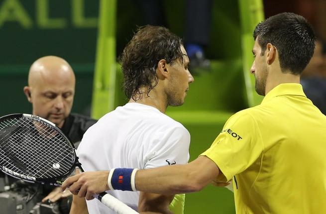 Novak Djokovic of Serbia shakes hands with Rafael Nadal of Spain after winning the final of the Qatar Open tennis tournament