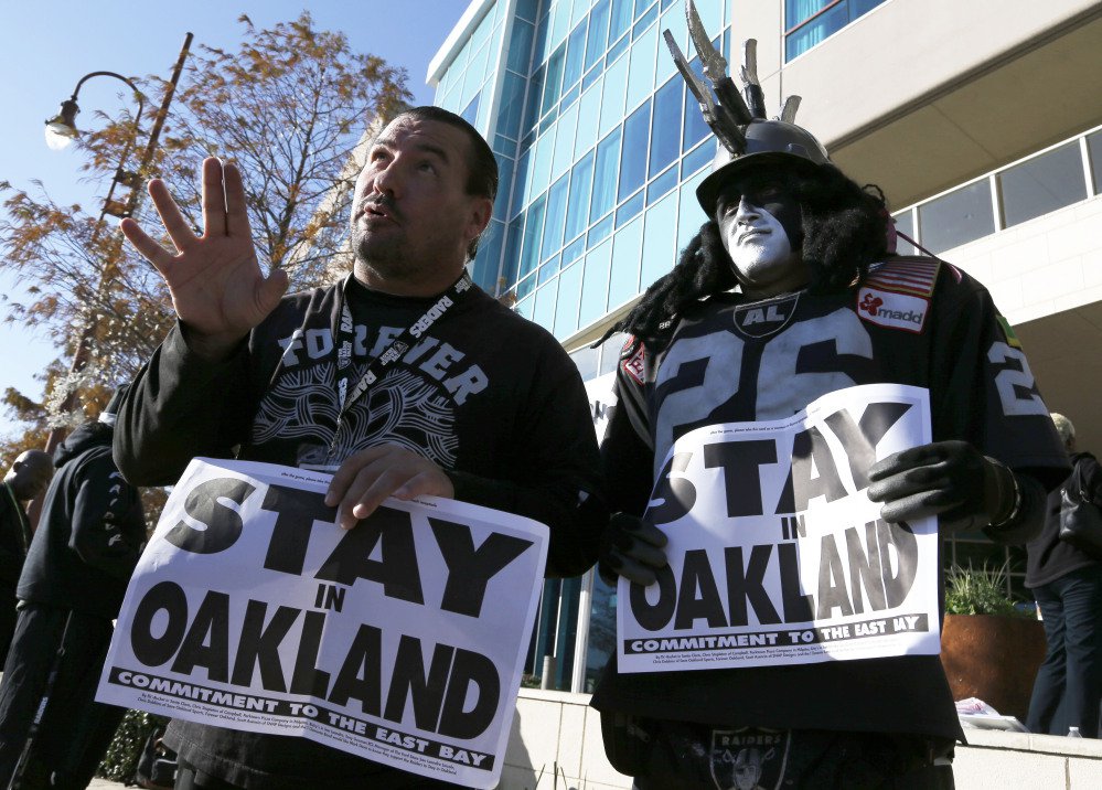 Oakland Raiders fans Griz Jones left and Ray Perez make their case for keeping the NFL football team in Oakland outside the Houston hotel where NFL owners were meeting Tuesday to discuss possible relocation to Los Angeles