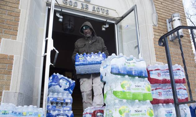 Maurice Rice organizes cases of water at the Joy Tabernacle Church on Monday Jan. 11 2016 in Flint Mich. Michigan Gov. Rick Snyder pledged Monday that officials would make contact with every household in Flint to check whether residents have bottled