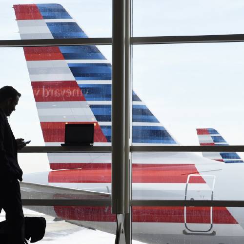 Arlington Va. talks on the phone as he waits for his flight to Boston at Washington's Ronald Reagan National Airport Monday Jan. 25 2016. Flights remained delayed or canceled in the aftermath of a massive weekend blizzard