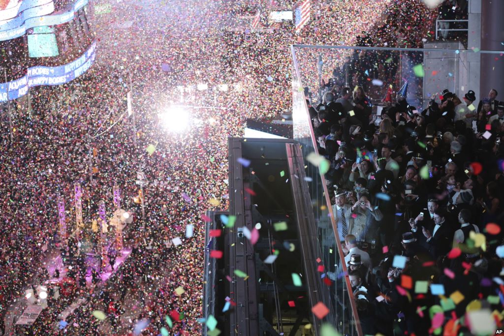 Revelers celebrate as confetti flies over New York's Times Square after the clock strikes midnight during the New Year's Eve celebration as seen from the Marriott Marquis hotel Friday Jan. 1 2016