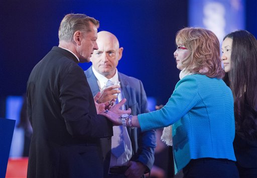 Father Michael Pfleger left Pastor at Saint Sabina Catholic Church in Chicago speaks with former Rep. Gabby Giffords D-Ariz. right and her husband Mike Kelly center right before taking their seats for President Barack Obama's televised town hall