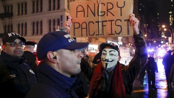 A protester holds up a sign in front of a New York City police officer on Dec. 28 2015 after an Ohio grand jury cleared two Cleveland police officers in the November 2014 fatal shooting of 12-year-old Tamir Rice