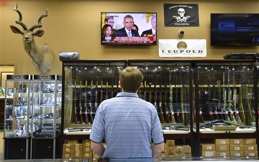 Brett Busbee sales associate at Southeastern Armory a gun store in Augusta Ga. watches as President Obama speaks at the White House about his gun control measures Tuesday Jan. 5 2016. President Obama unveiled his plan Tuesday to tighten control and