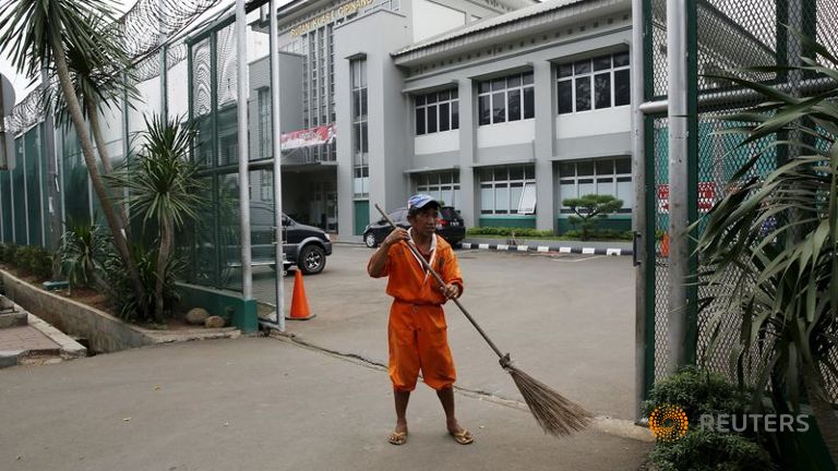 S A worker sweeps a street at the gate of Cipinang prison in Jakarta