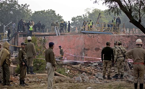 As Indian security personnel cordon off the area investigators inspect the site where a small Indian paramilitary plane crashed outside the main airport in New Delhi India Tuesday Dec. 22 2015. An inquiry has been ordered to determine that cause of