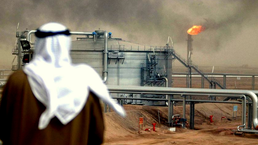 Saudi man infront of an oil derrik