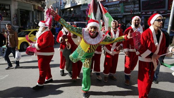 Palestinians dressed up as Santa Claus distribute gifts Ramallah West Bank