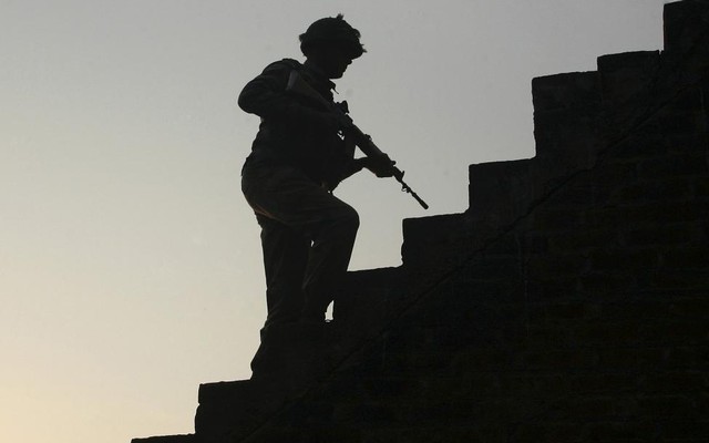 An Indian army soldier climbs up stairs to take his position on the rooftop of a residential house outside the Indian Air Force base at Pathankot in Punjab India