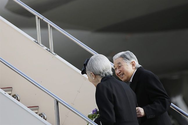 Japan's Emperor Akihito smiles at Empress Michiko as they board their airplane to leave for the Philippines at Haneda international airport in Tokyo Tuesday Jan. 26 2016. Akihito is heading to the Philippines for a four-day visit to a country that suff