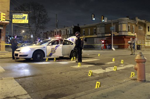 Officers investigate the scene of a shooting Friday Jan. 8 2016 in Philadelphia. A Philadelphia police officer was shot multiple times by a man who ambushed him as he sat in his marked police cruiser authorities said