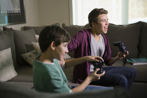 Gamers playing video games on sofa