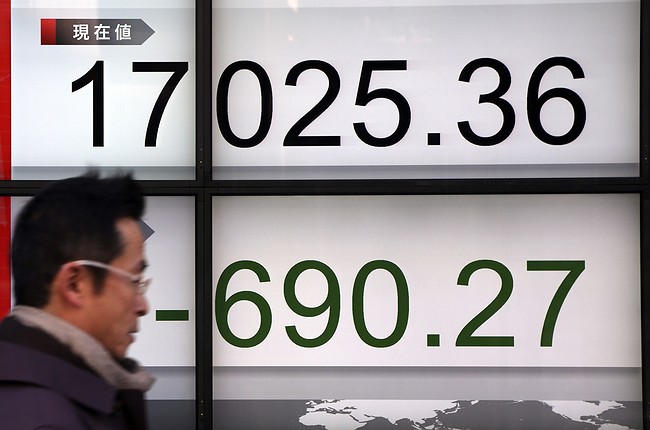 Eugene Hoshiko- A man walks past an electronic stock board of a securities firm in Tokyo Thursday Jan. 14 2016