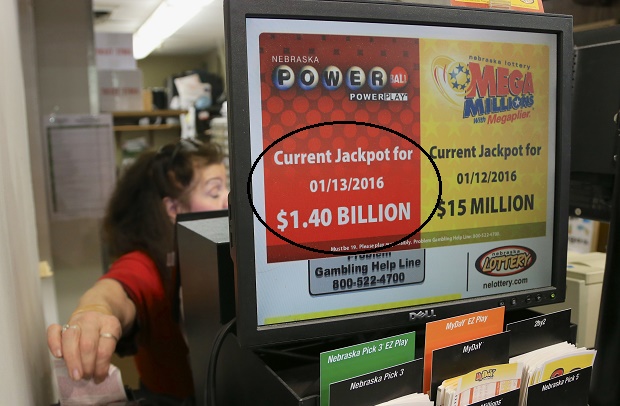 A worker at Russ's Market in Lincoln Neb. reaches for a Powerball ticket Monday Jan. 11 2016. The Powerball jackpot has grown to over a billion dollars and the drawing is still two days away