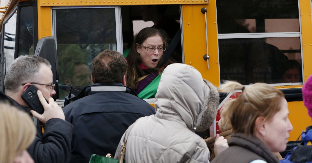 A school bus driver yells to a parent that their child is safe after a bus accident at Amy Beverland Elementary School that left several students injured and one adult dead on school grounds on Jan. 26 2016 in Indianapolis Ind