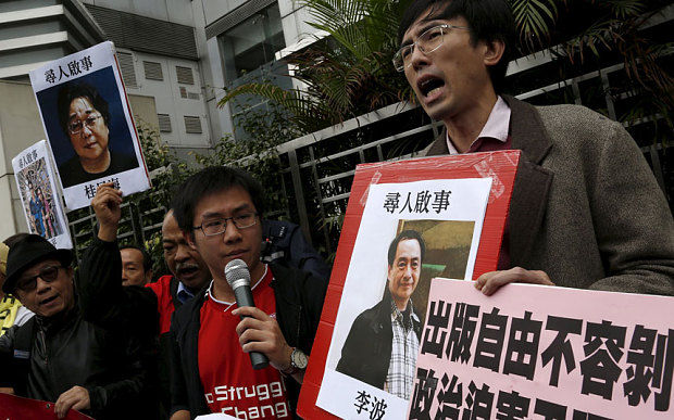 Pro-democracy demonstrators hold up portraits of Causeway Bay Books shareholder Lee Bo during a protest