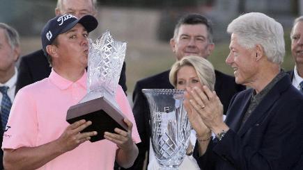 Jason Dufner left kisses the trophy with former United States President Bill Clinton right after winning the Career Builder Challenge