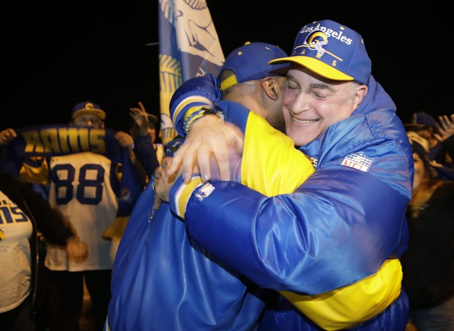 Football fans hug after the announcement of the return of the Rams to Los Angeles on the site of the old Hollywood Park racetrack in Inglewood Calif. Tuesday Jan. 12 2016. NFL owners voted Tuesday night to allow the St. Louis Rams to move to a new