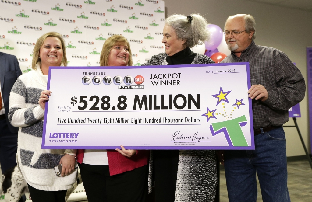 Rebecca Hargrove second from right president and CEO of the Tennessee Lottery presents a ceremonial check to John Robinson right his wife Lisa second from left and their daughter Tiffany left after the Robinson's winning Powerball ticket was