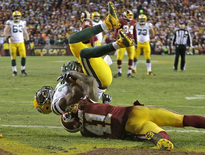 Packers wide receiver Randall Cobb hauls in a touchdown pass in the second quarter while being pulled down by Washington Redskins cornerback Will Blackmon