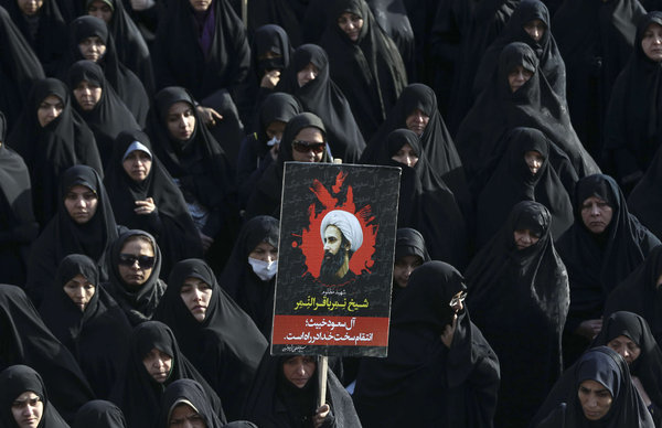 An Iranian woman holds a poster of Sheikh Nimr al-Nimr a Shiite cleric executed by Saudi Arabia