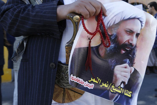 A Shi'ite protester carries a poster of Sheikh Nimr al Nimr during a demonstration outside the Saudi embassy in Sanaa Oct. 18 2014