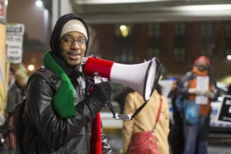 Nino Brown speaks into a megaphone during a Justice for Tamir Rice protest at Jackson Square MBTA station in Roxbury on Tuesday December 29