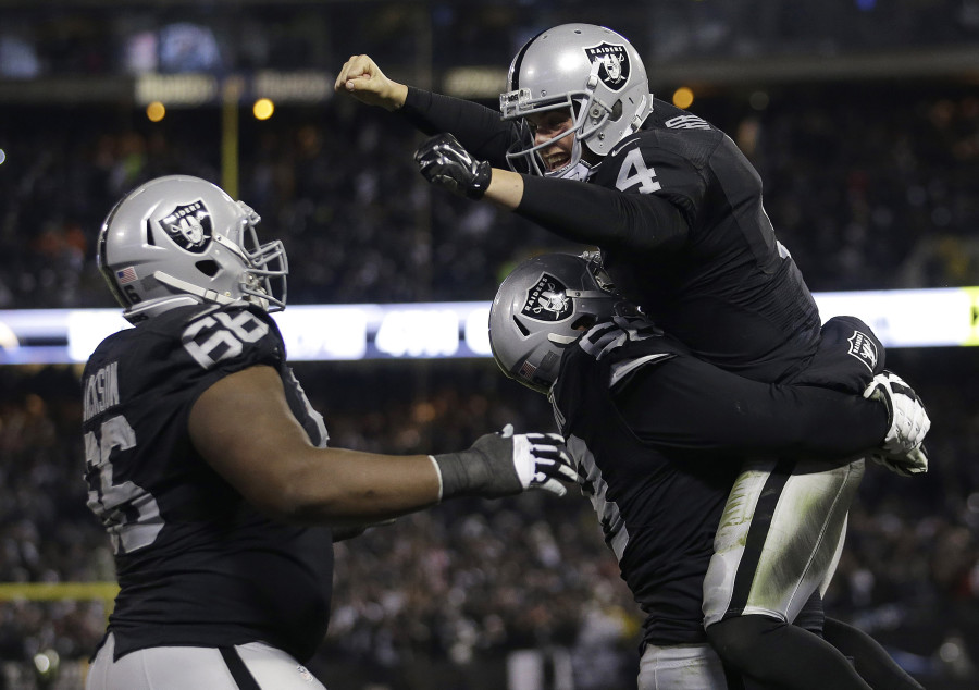 Oakland Raiders quarterback Derek Carr top celebrates with guard Gabe Jackson left and offensive guard Jon Feliciano after the Raiders scored against the San Diego Chargers during the second half of an NFL football game in Oakland Calif. Thursday D