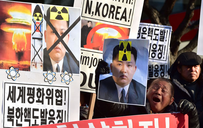 South Korean conservative activists shout slogans with placards showing portraits of Kim during a rally denouncing North Korea’s hydrogen bomb test in Seoul. — AFP