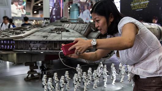 A visitor takes a selfie with a model of the Millennium Falcon from the Star Wars movies at the 17th Ani Com and Games exhibition in Hong Kong