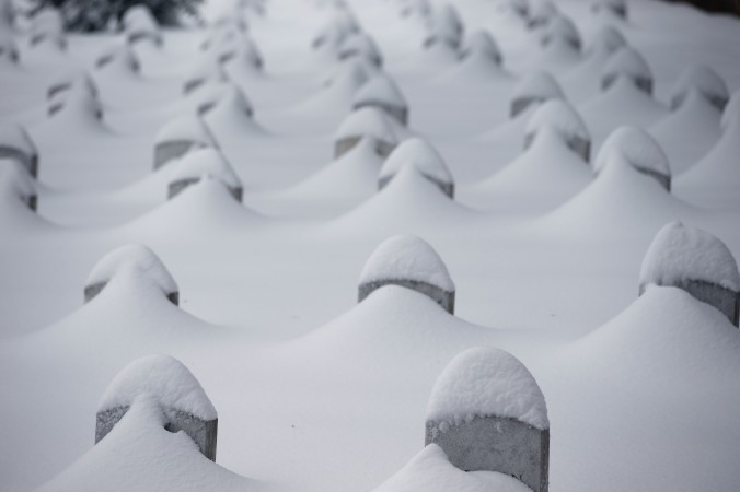 Headstones are nearly covered by snow at Arlington National Cemetery Saturday Jan. 23 2016 in Arlington Va. A blizzard with hurricane-force winds brought much of the East Coast to a standstill Saturday dumping as much as 3 feet of snow stranding ten