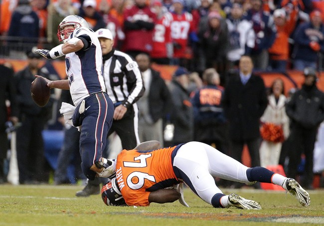 New England Patriots quarterback Tom Brady passes the ball as he is taken down by Denver Broncos outside linebacker De Marcus Ware during the second half of the AFC Championship game between the Denver Broncos and the New England Patriots Sunday Jan. 24